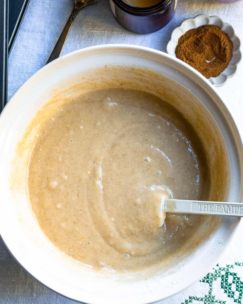 A bowl of donut batter with a spatula in it.