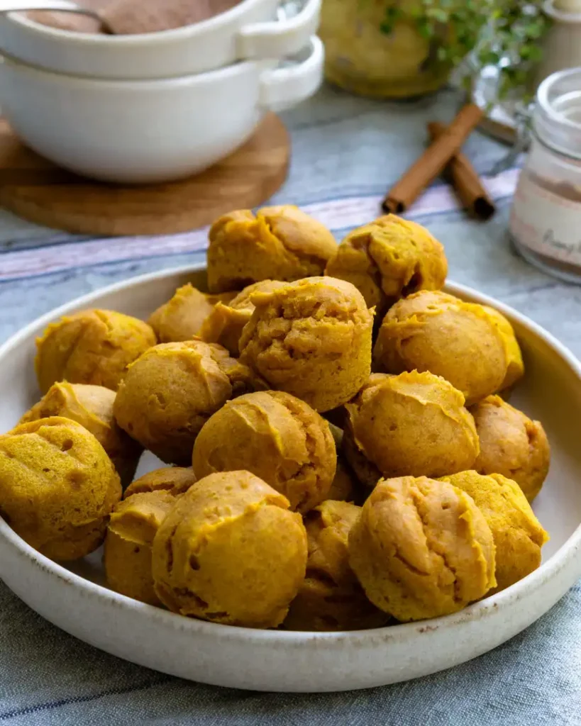 Baked gluten-free pumpkin bites piled onto a plate.