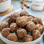 Cinnamon sugar pumpkin bites with a glaze. The pumpkin bites are piled onto a plate.