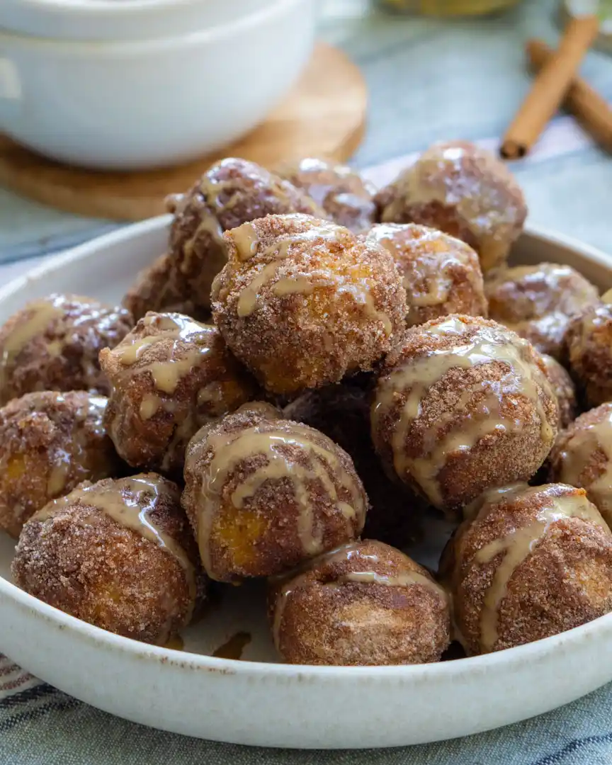 A pile of donut bites on a plate.