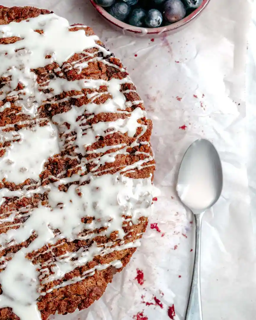 Photo of half of a round coffee cake with a spoon full of glaze next to it.