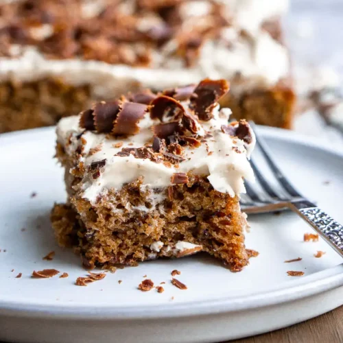 A sliced of cake on a plate with a fork.