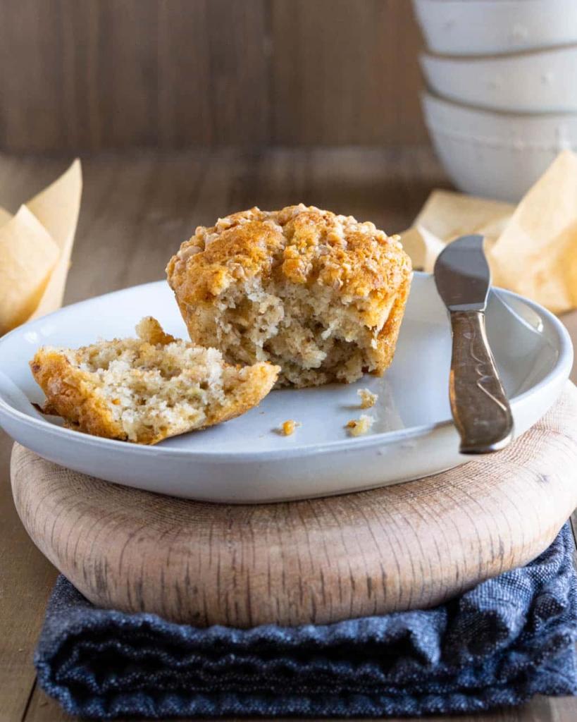 Piece of banana muffin with a piece taken off on a plate