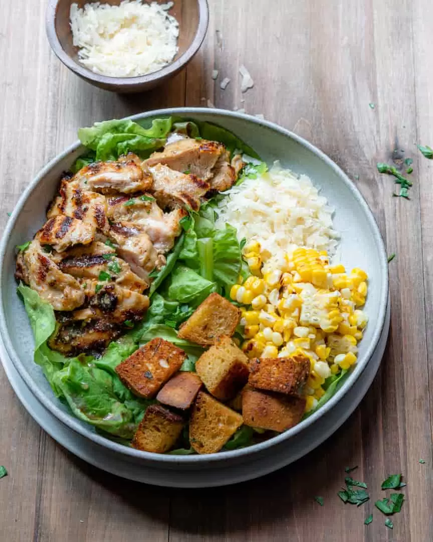 A bowl of grilled chicken with salad toppings