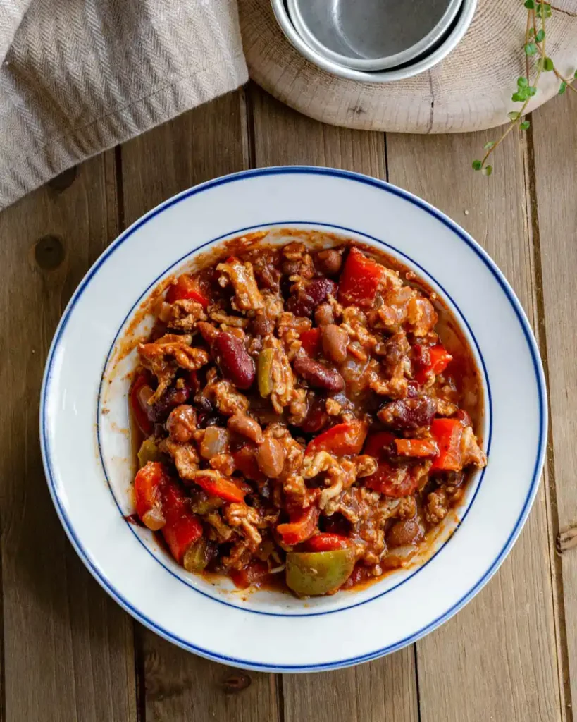 A bowl of cooked chili with no toppings.