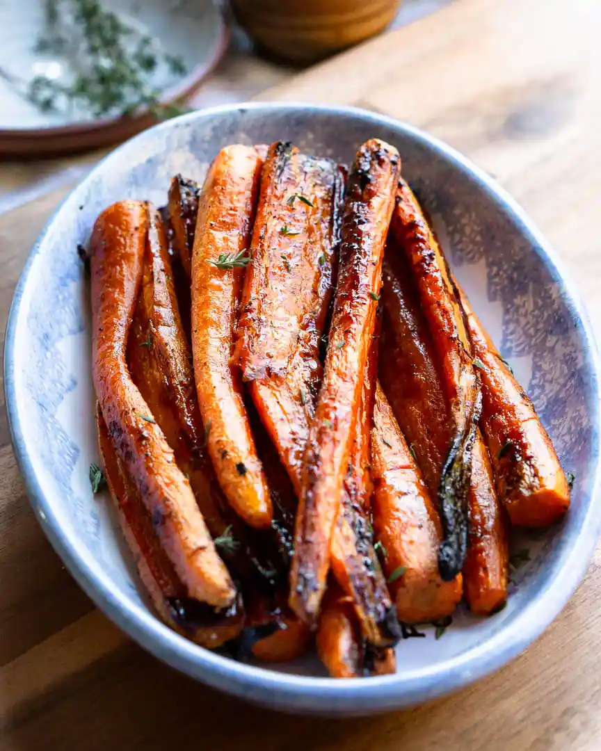 Roasted carrots stacked on a serving platter.