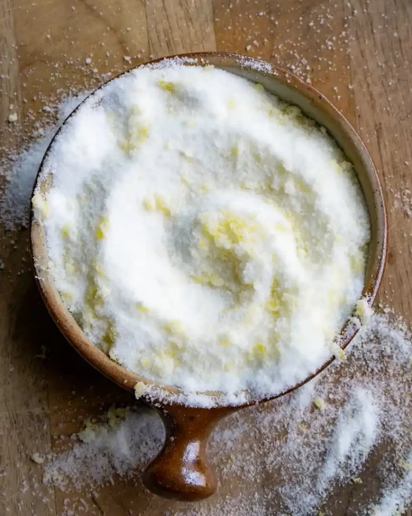 A small bowl of sugar with lemon zest mixed into it