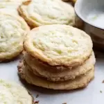 Lemon butter sugar cookies stacked with other cookies nearby