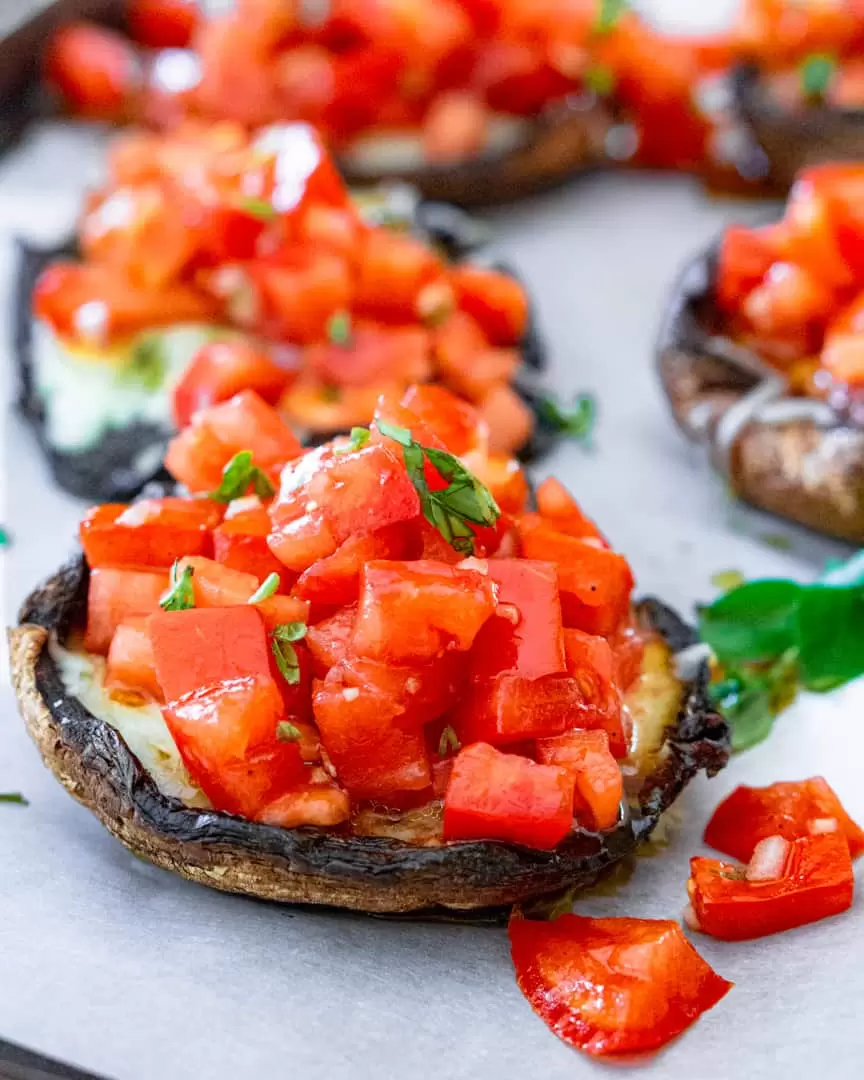 Grilled portobello mushroom with bruschetta on top of it.