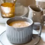 A mug of tea with cinnamon on top