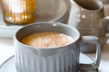 A mug of tea with cinnamon on top