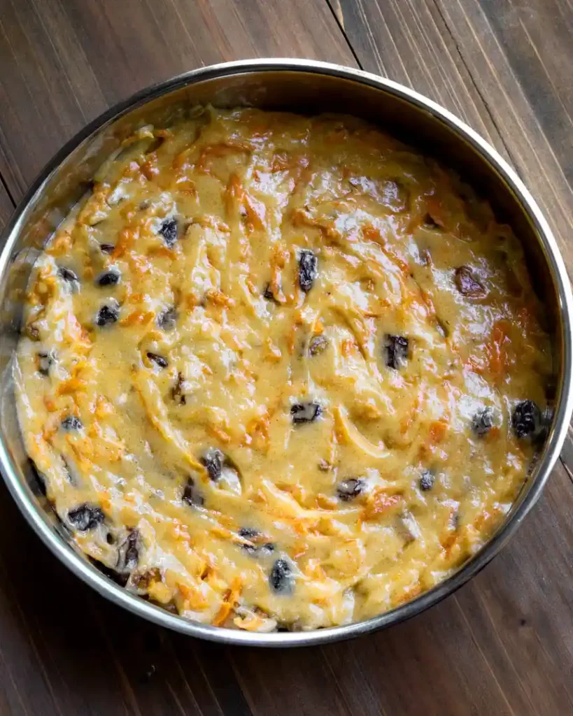 Unbaked carrot cake in a round baking pan.