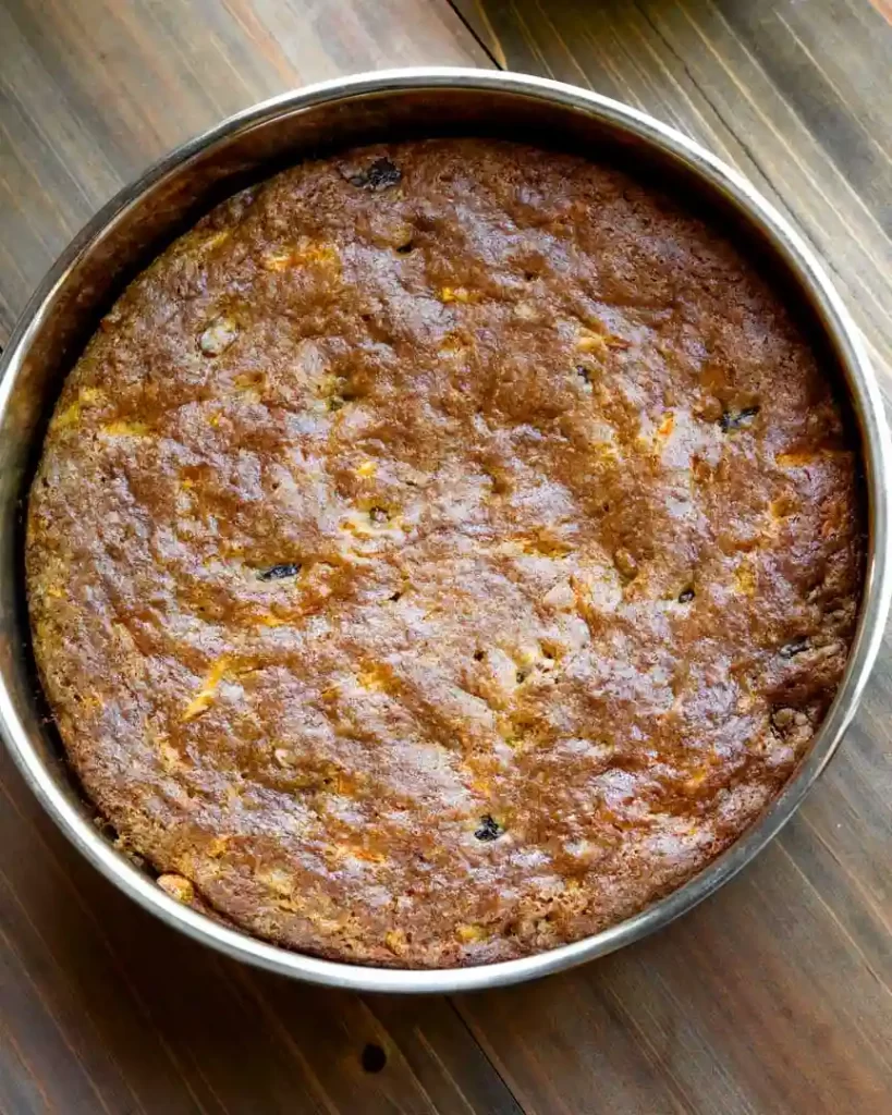 A baked carrot cake in a round baking pan.