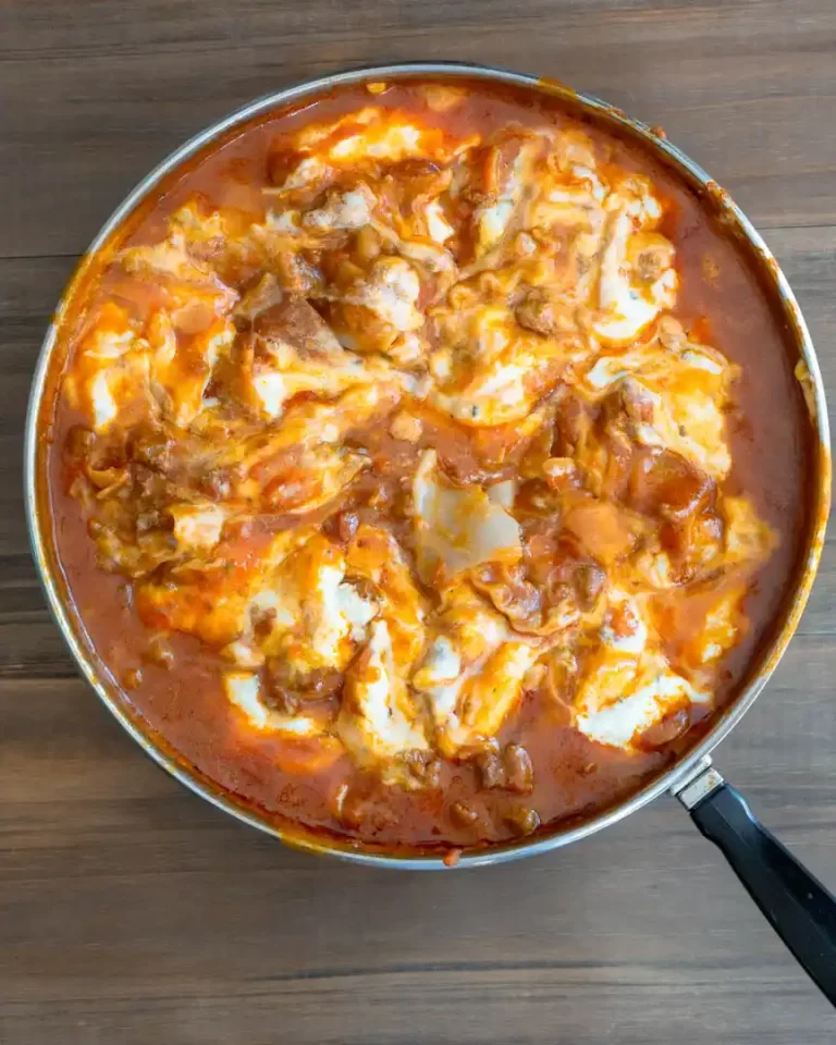 A skilled of lasagna with ricotta cheese swirled into the sauce.