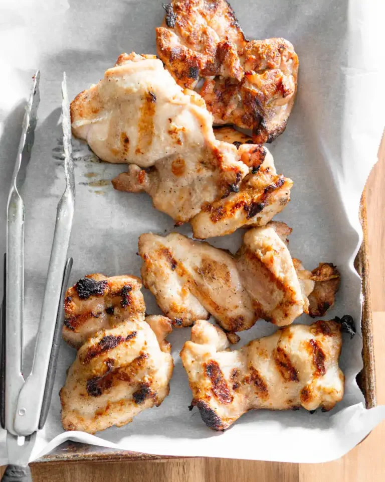 Grilled chicken thighs on a platter.