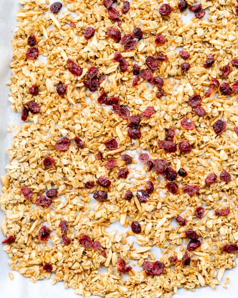 Baked granola with dried cherries on a baking sheet.