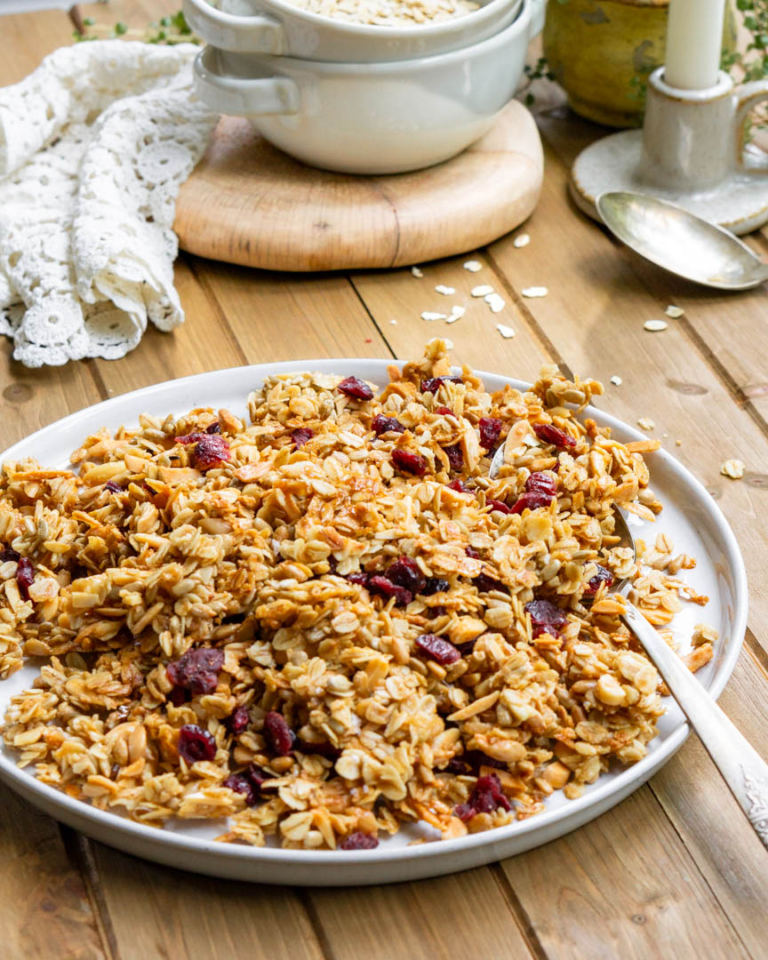 A plate of cherry & almond granola with a spoon.