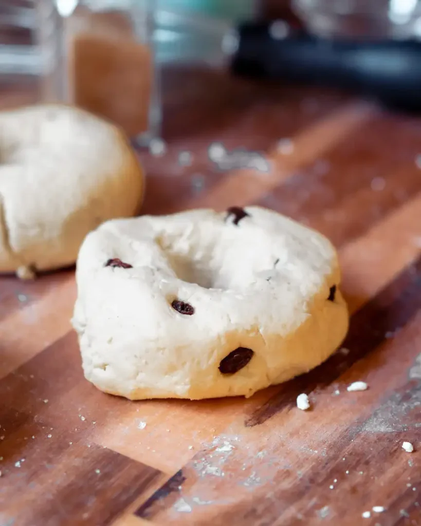 An uncooked high protein bagel with raisins.