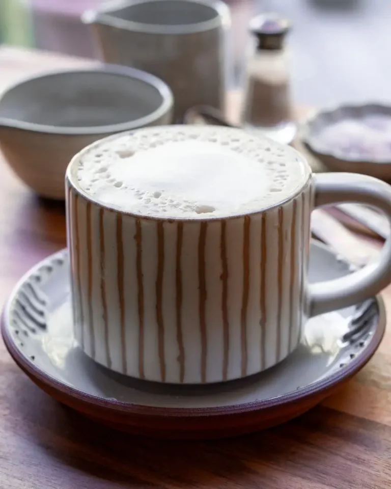 A mug filled with maple sea salt latte. The mug sits on a small plate.