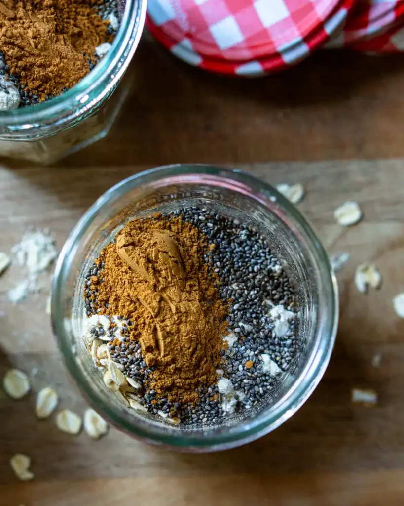 Top down view into a jar of oats, chia seeds, and spices.