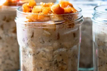 Several jars of overnight oats topped with sautéed apples.