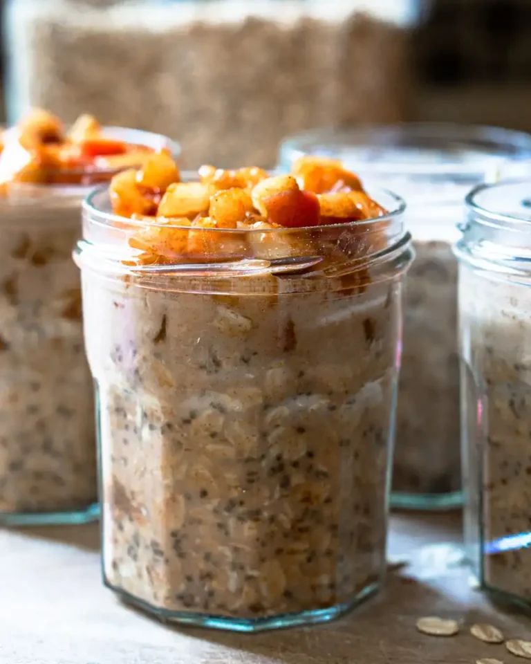 Several jars of overnight oats topped with sautéed apples.