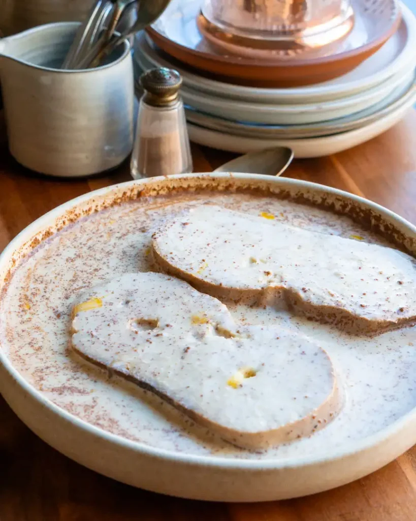 Two slices of dipped bread in an eggnog mixture.