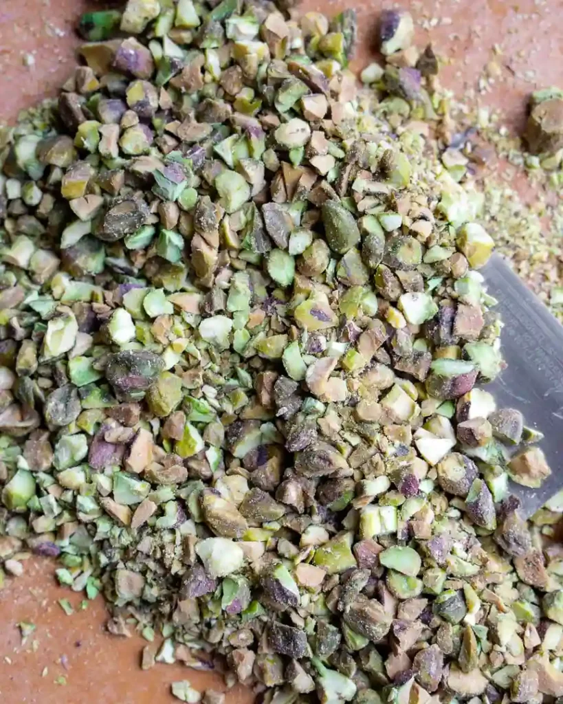 Chopped pistachios on a cutting board.