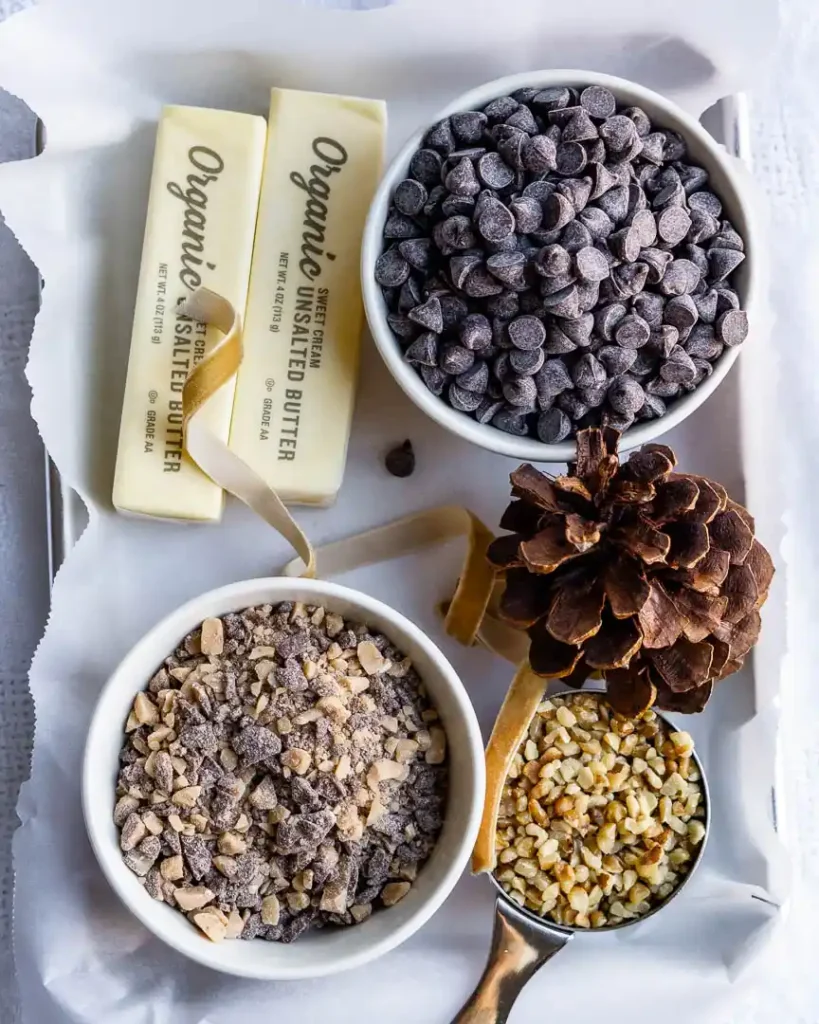 A tray piled with cookie ingredients, including, butter, walnuts, chocolate chips, toffee bits.