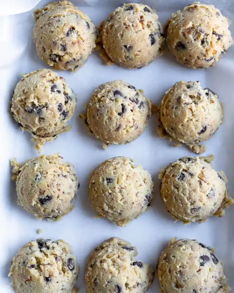 Cookie dough on a tray lined up next to each other for freezing.