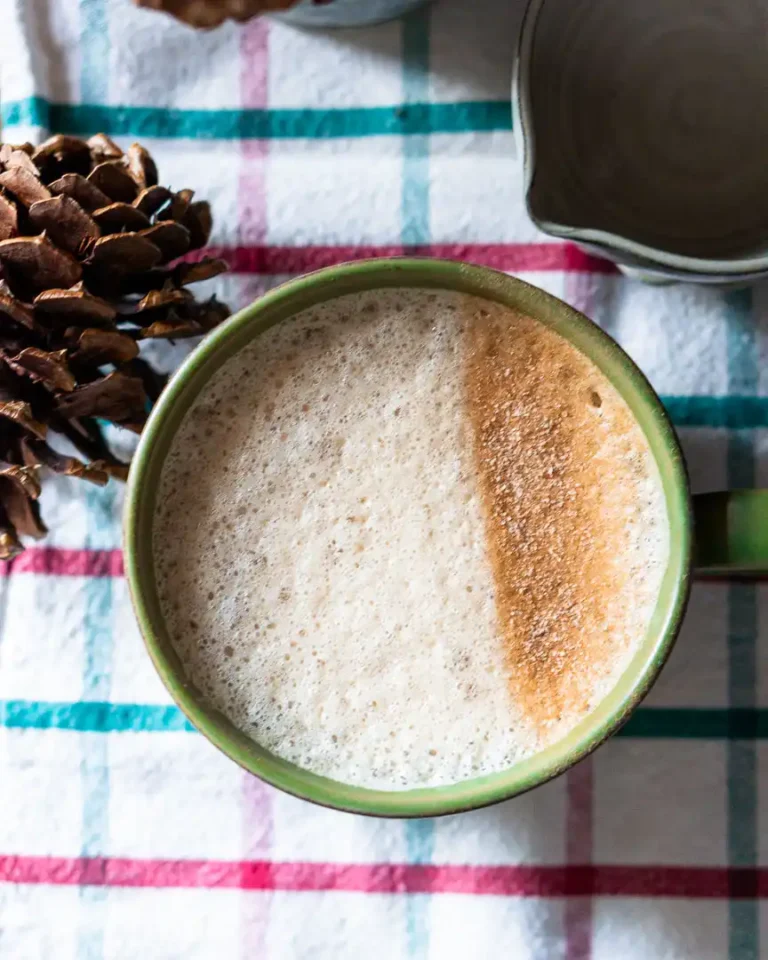 A top down view of gingerbread latte. Half of the milk foam is dusted with cinnamon sugar.