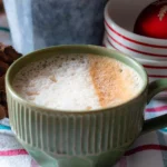 A mug of gingerbread latte. One side of the milk is dusted with cinnamon sugar.