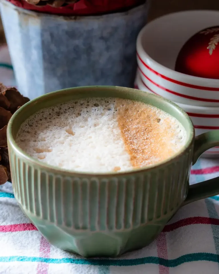 A mug of gingerbread latte. One side of the milk is dusted with cinnamon sugar.