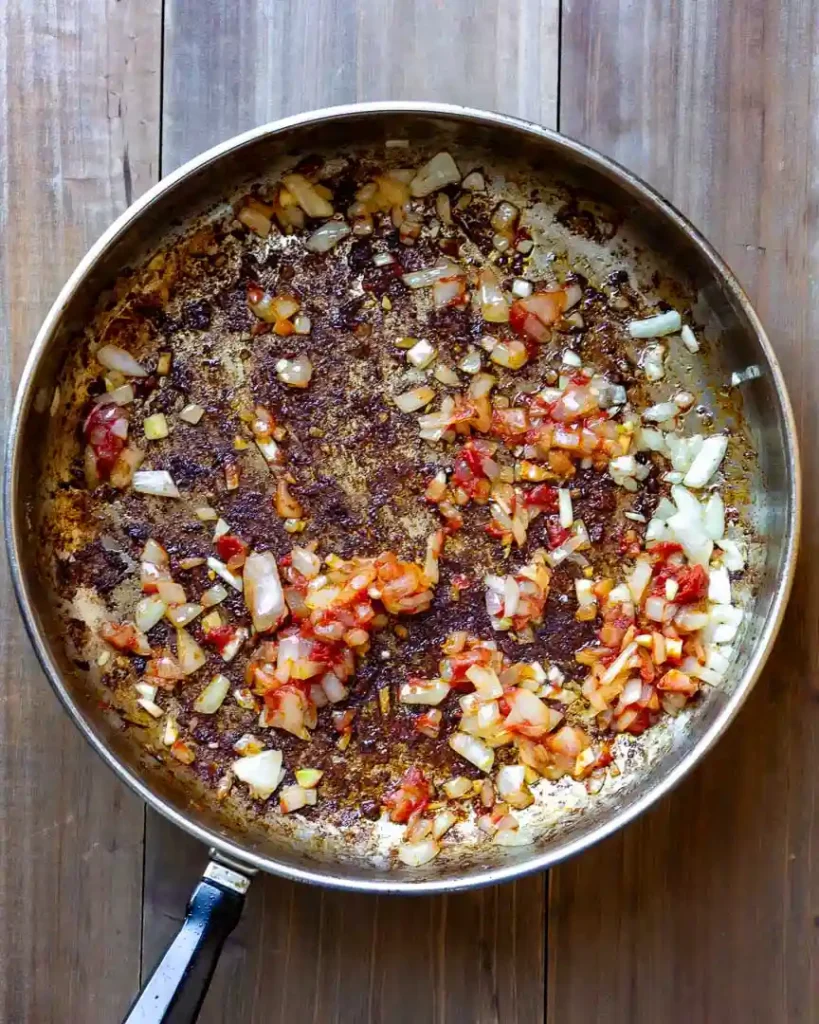 A skill with sautéed onions, garlic and tomato paste.