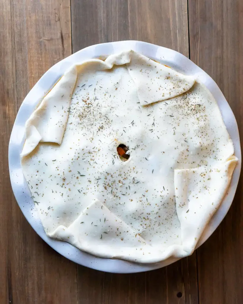 Unbaked puff pastry on top of beef pot pie filling.